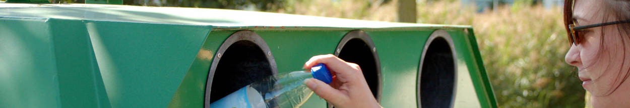 Vrouw gooit een fles in glasbak