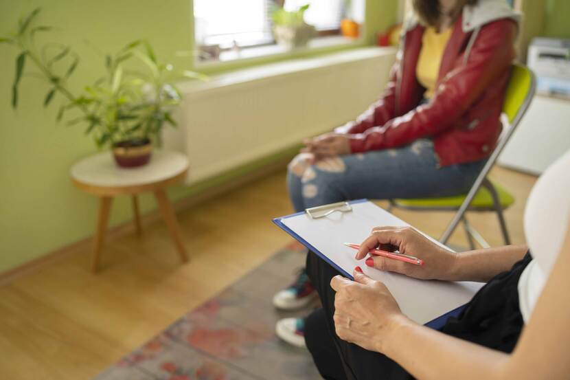 Vrouw met schrijfblok en meisje op de achtergrond