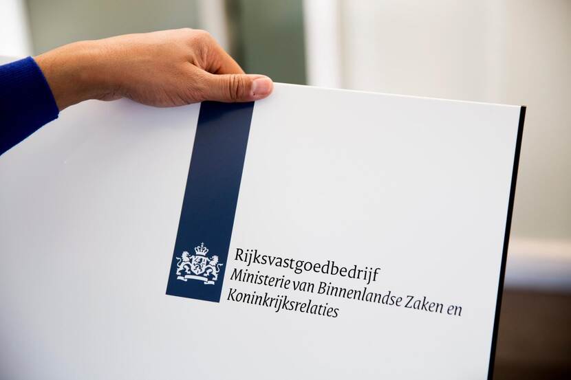 Afbeelding van het rijkslogo dat bestaat uit een blauwe, verticale balk (het lint) met het rijkswapen en daarnaast de naam van de betreffende organisatie van de Rijksoverheid